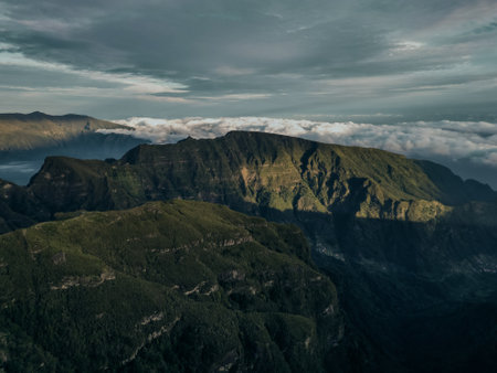 A stunning view of the first rays of the sun bathing the rugged peaks of the madeira mountains in a...