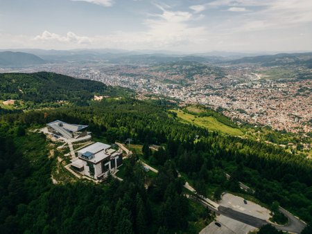 A captivating aerial view of Sarajevo's cityscape nestled amidst the scenic hills of Bosnia and...