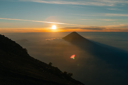 Silhouette of volcano de agua at firey orange sunrise seen from the top of volcano de acatenango, guatemala. High quality photoの写真素材