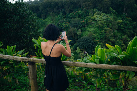 girl's head with flower in hair. Overlooking the views. Lush greenery, overcast skies. Scenic. Nature. Outdoors. High quality photoの写真素材