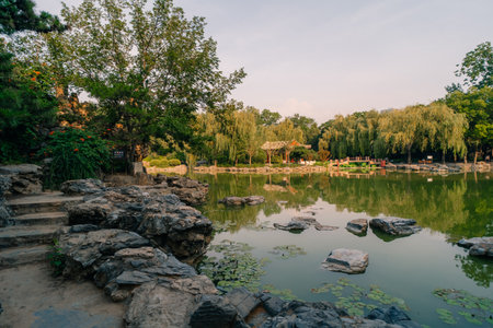 Ornate pavilion mirrored in a lake of the historical Ritan Park which means Park of the Sun, Beijing, Chinaの写真素材