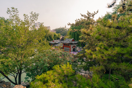 Ornate pavilion mirrored in a lake of the historical Ritan Park which means Park of the Sun, Beijing, Chinaの写真素材