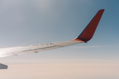 Wing of a flying aricraft with blue sky. High quality photo
