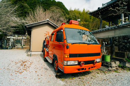 A large, orange fire engine is parked sideways near temple in Japan. High quality photoの写真素材