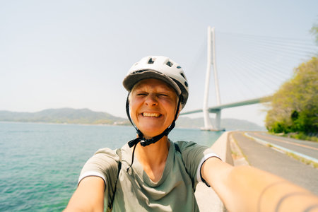 shikoku, japan - August 3, 2025 Female cyclist on Shimanami kaido cycling route. High quality photo