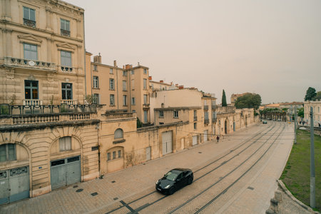 Early morning view of historic Porte du Peyrou arch of triumph with French flag and St Anne church bell tower, ancient landmarks of Montpellier, Franceのeditorial素材