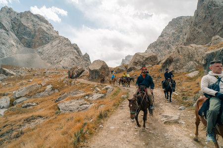 Tourists on horseback in Kurumduk valley Naryn province, Kyrgyzstan - 3 September 2025. High quality photoのeditorial素材