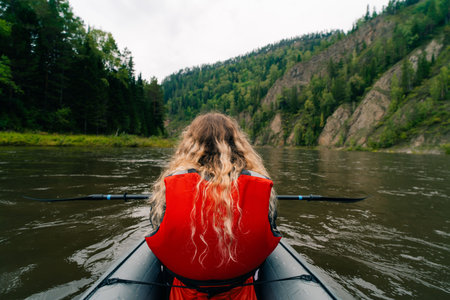 Girl in a life jacket rafting on a packraft on the river. High quality photoの写真素材