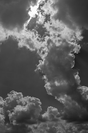 The sky is cloudy and the sun is shining through the clouds. The clouds are white and grey, and they...