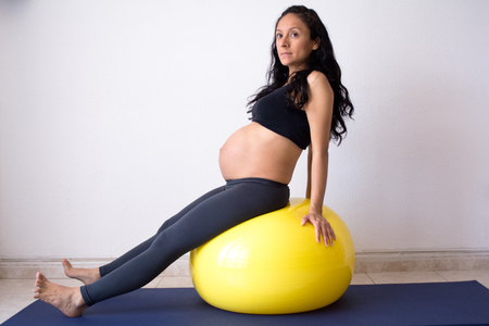 Pregnant woman doing excercise with a pilates ballの写真素材