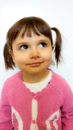 Little girl thinking or dreaming. Eyes looking upの写真素材