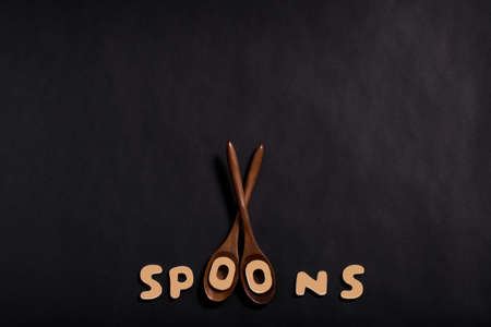 Wood Spoons spelled out on Black Backgroundの写真素材