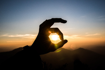 Ok hand sign silhouette at sunsetの写真素材
