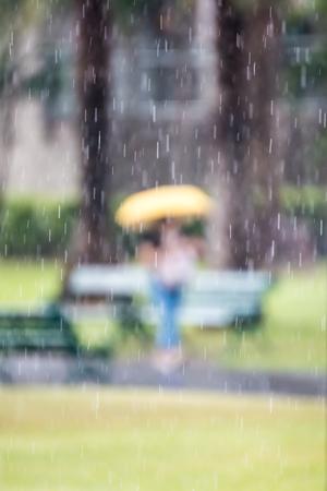 Woman walking down the street in rainy day. Intentional motion blurの写真素材