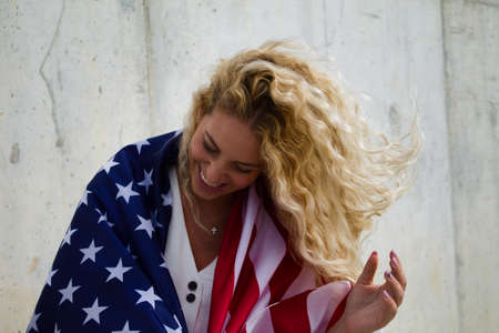 blond girl happy with USA flagの写真素材