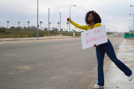 black africa-american woman hitch-hiking on a highway outside of the city travel to the happinessの写真素材
