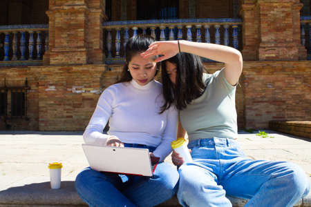 young asian LGTB lesbian couples with rainbow flag in a square. They are kissing. Concept of romance, love and same-sex relationshipsの写真素材