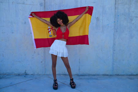 Beautiful afro american woman playing with soap bubbles. The woman is blowing the bubbles and hides among the soap bubbles. Happiness conceptの写真素材