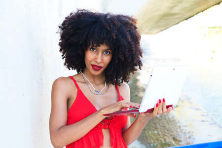 beautiful afro-american woman sitting with her laptop in a park. The photo is taken from above and you can see the girl below. Concept college studentの写真素材