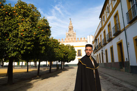 Portrait of young and handsome gipsy man, dressed in black and red shoes and with a black and yellow bullfighter's cape over his shoulders in Seville. Flemish cultural heritage of humanity.の写真素材