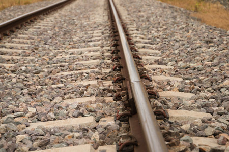 Detail of the rail of the railway track, stones, screw and wooden sleepers. Concept of means of transportの写真素材