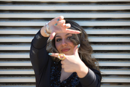 The woman's hands frame a distant view on the horizon. Woman making a frame around the view with her hands, future planning concept. business concept. Concept of planning and vision for new yearの写真素材