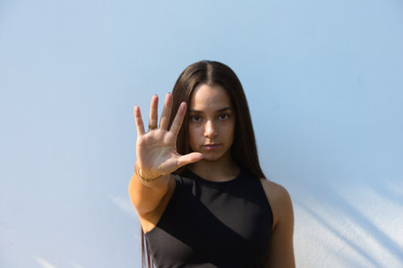Woman shows the STOP camera gesture. She fights for gender equality, against domestic violence. Concept of a global women's rights movement. Isolated backgroundの写真素材
