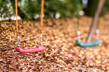 Empty swing with leaves in the autumn seasonの写真素材