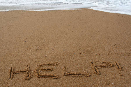 Word help spelled in the sand on a beachの写真素材