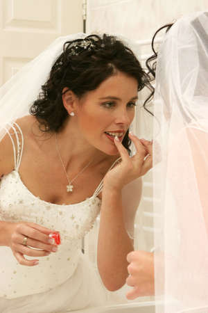 Young bride on her wedding day doing her makeupの写真素材