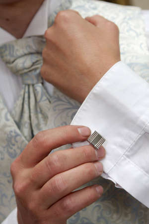 A groom putting on his cuflings