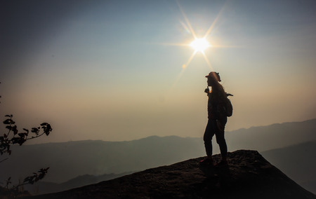 woman holds up thumb successful in climbing on the cliffの写真素材