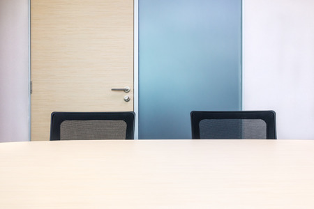 The metting room have wood desk and black chairs. Office interview roomの写真素材