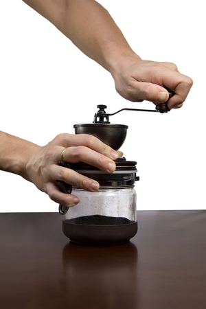 Man is grinding a manual coffee grinder isolated on white backgroundの写真素材