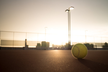 Tennis ball on court at dawn timeの写真素材