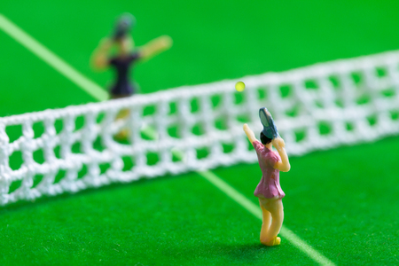 Tennis player figurines playing tennis on grass courtの写真素材