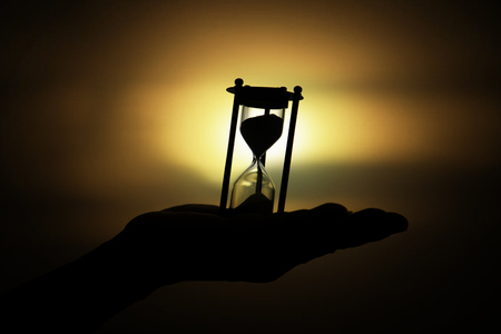 Silhouette hourglass on handの写真素材