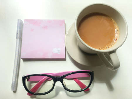 Notes, coffee and glasses on the workbenchの写真素材
