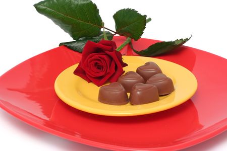 Chocolate heart on plates and a roseの写真素材