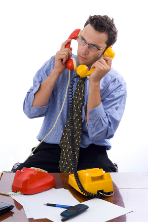 Busy businessman talking on two telephones in the same timeの写真素材