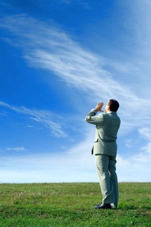 Businessman in the nature, shouting loud, communicating an important message to everyoneの写真素材