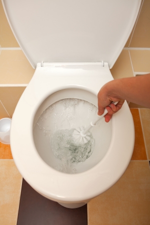 Hand washing the open toilet with brushの写真素材