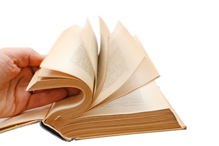 Man's hand leafing fast an old bookの写真素材