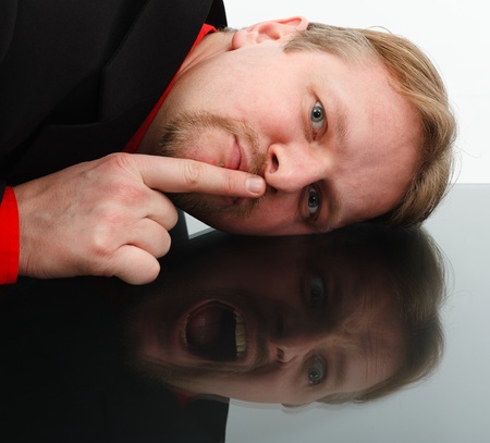 Man showing silence while shouting loud in the mirrorの写真素材