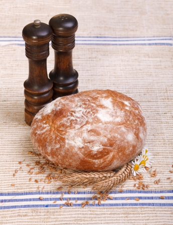 Traditional bread on canvas tablecloth with salt and pepper shakerの写真素材