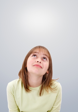 Teenager girl looking up dreamily to copy spaceの写真素材