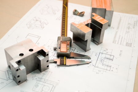 Caliper and finished parts on industrial drawing
