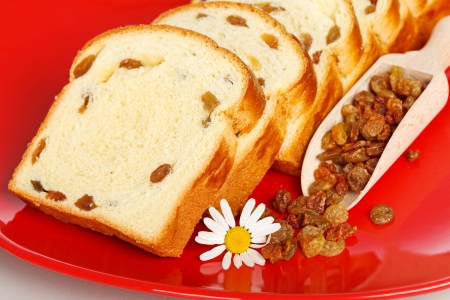 Macro of sweet loaf slices with raisins on red plateの写真素材