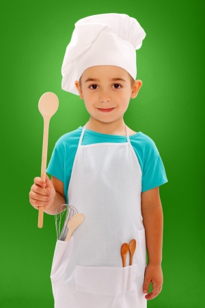 Little chef showing wooden spoon on blue backgroundの写真素材