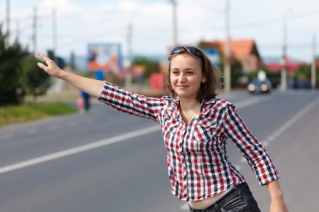 Teen girl hitch hiking on the roadの写真素材